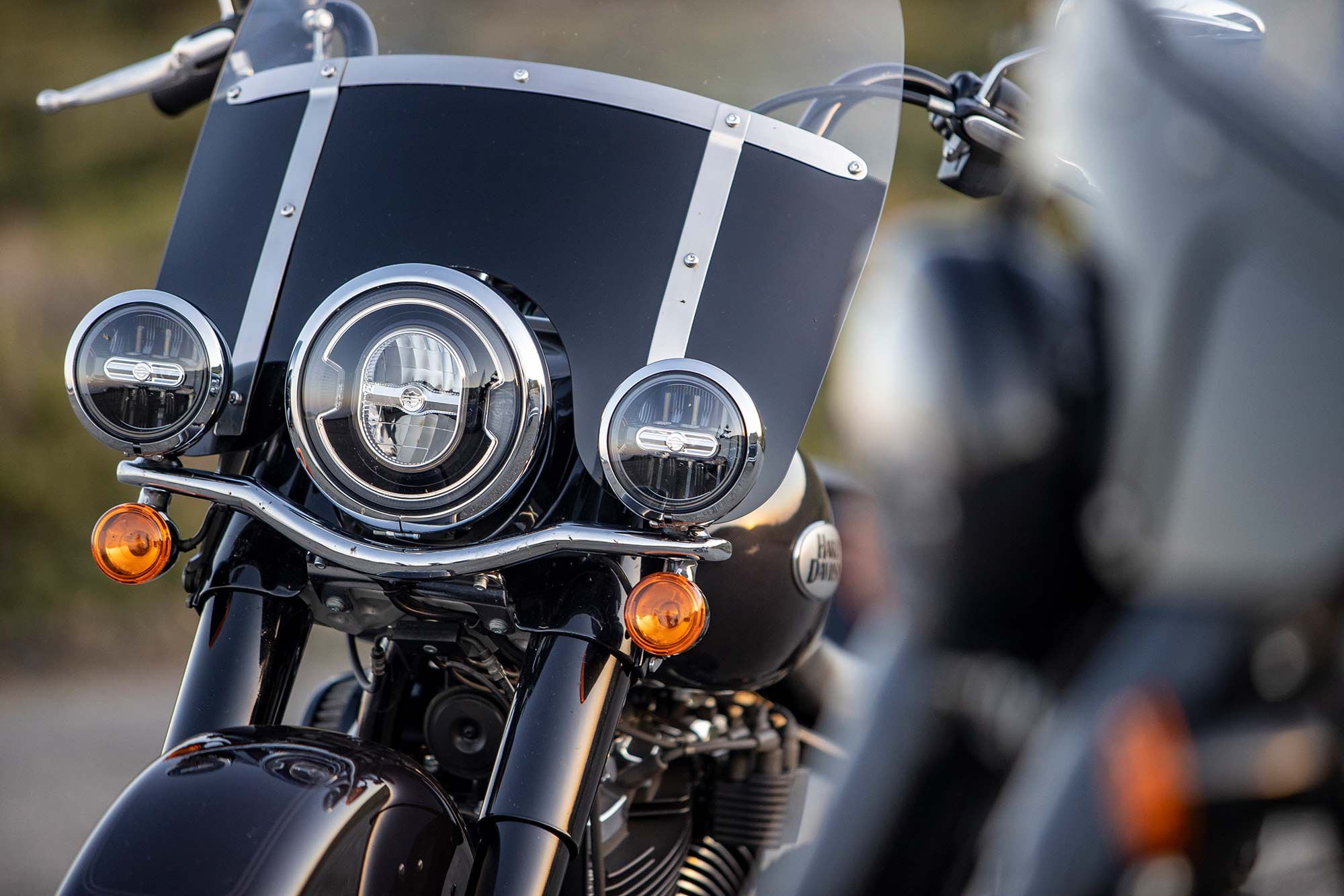 A chrome bar mounts the Heritage Classic’s fog lights and turn signals, with chrome headlight bezels and windshield hardware nearby.