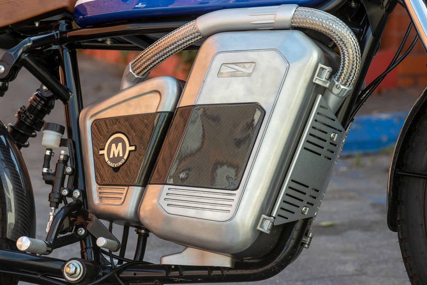 Batteries lay flat in the front compartment, while other electrical equipment is housed in the reward box. High-voltage wires run through the steel-braided hose. Notice the incredibly simple footpeg hanger.