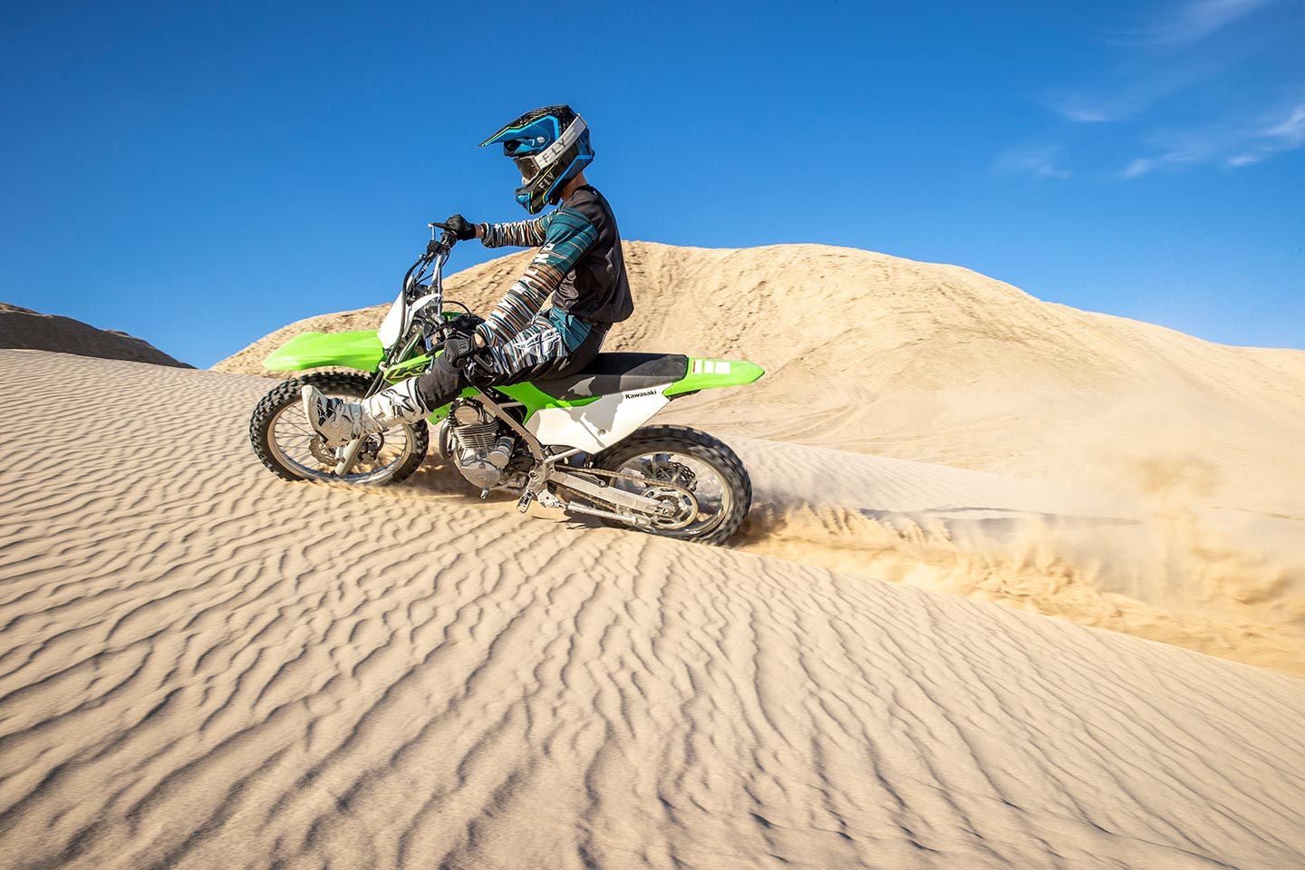 Carving through tiger-striped dunes.